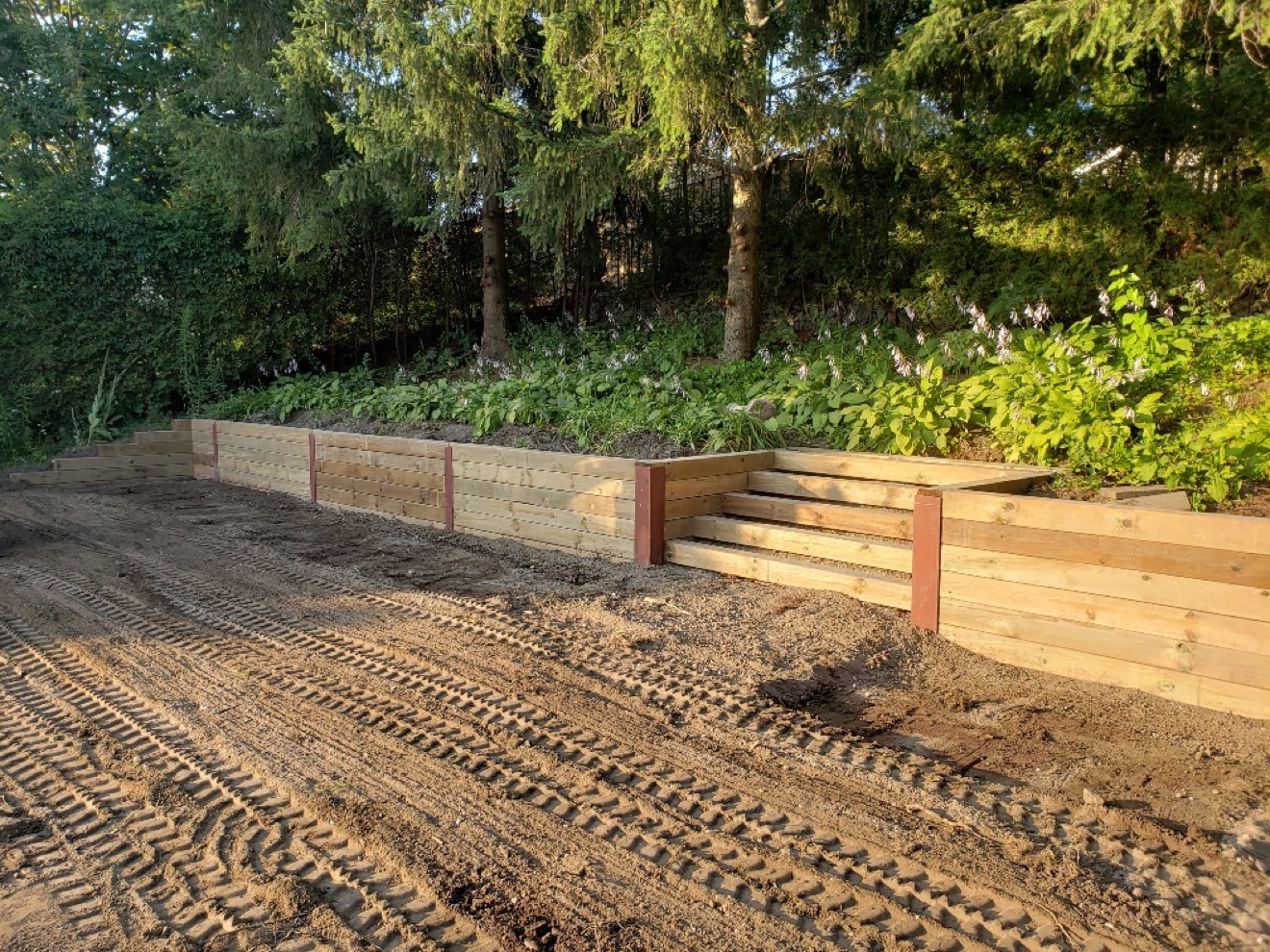 Timber retaining wall with steps and graded earth from a Manulock excavation project
