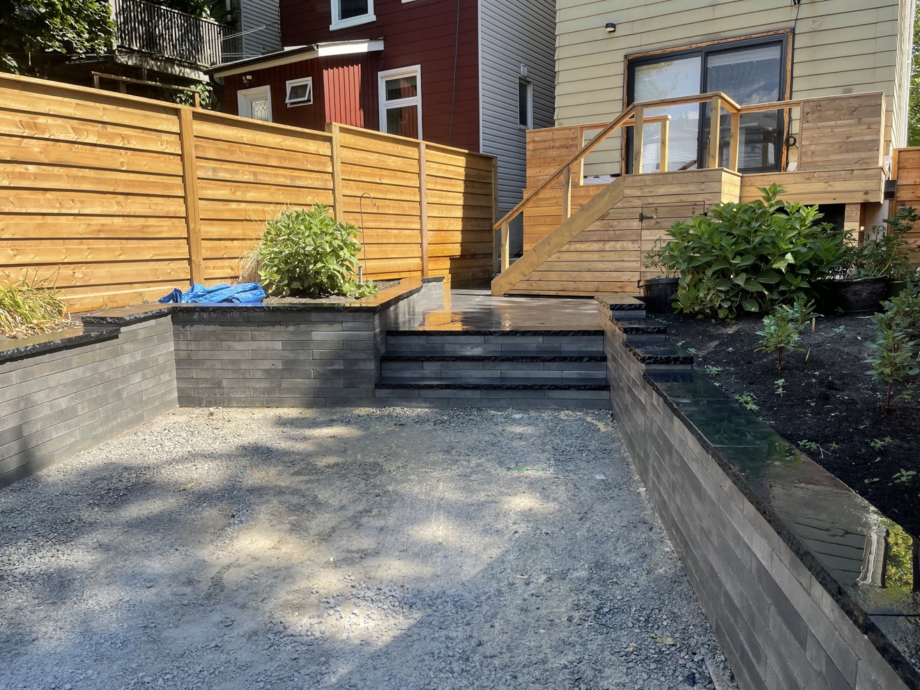 Wooden privacy fence with retaining walls and steps built by Manulock Construction