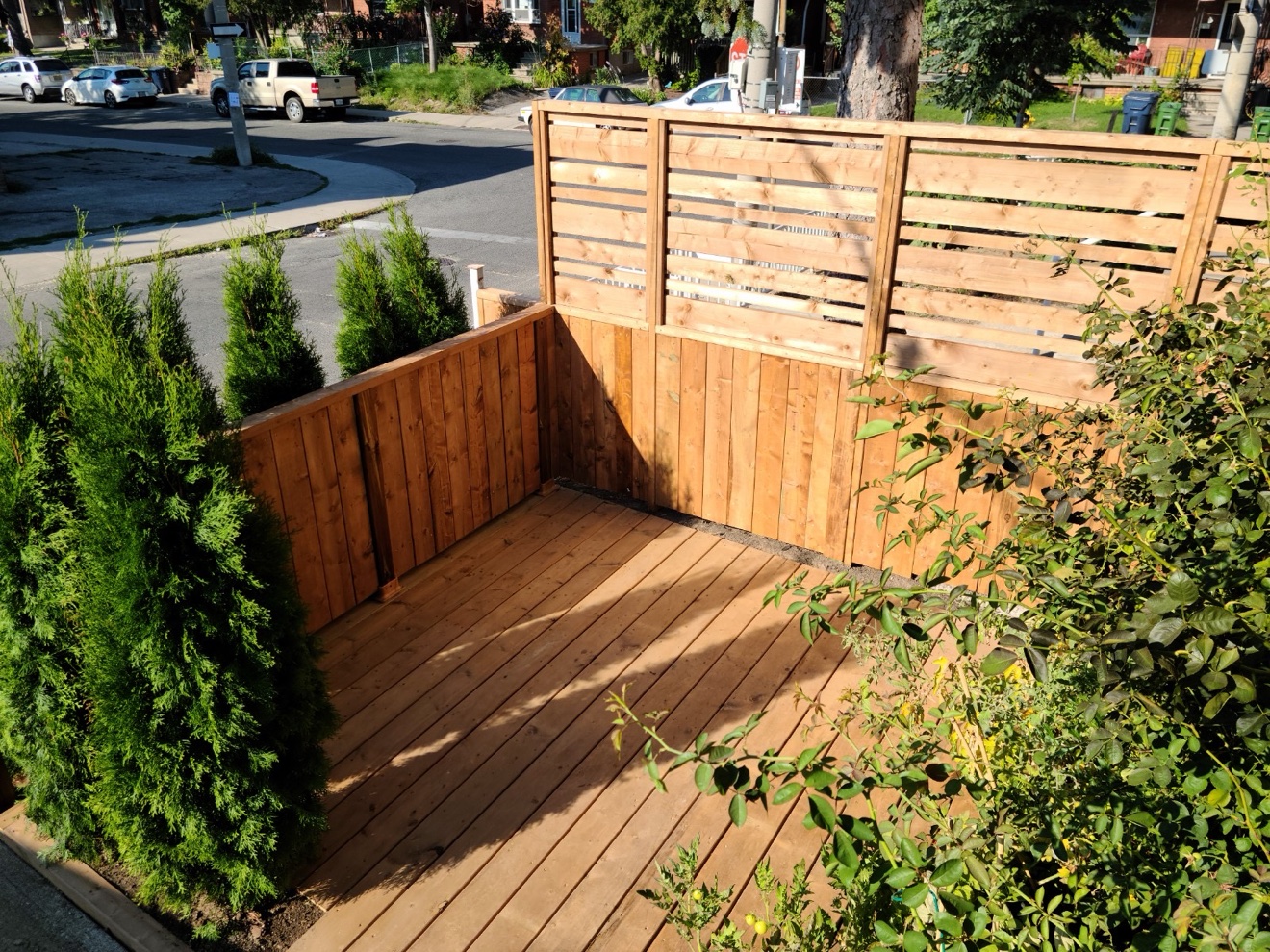 Cedar deck with horizontal-slat wooden privacy fence built by Manulock Construction